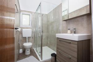 a bathroom with a shower and a toilet and a sink at Apartments by the sea Pirovac, Sibenik - 6447 in Pirovac +32 photos