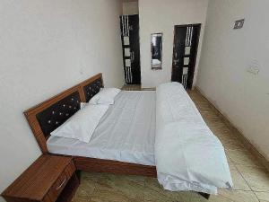 1 dormitorio con 1 cama grande con sábanas blancas en POP New Hotel Hometown en Noida