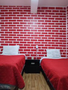 two beds in a room with a brick wall at Alo México in Mexico City