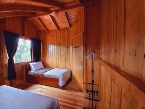 a room with two beds in a wooden cabin at Chalés Sol da Serra in Rio Rufino