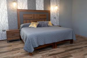 um quarto com uma cama grande e uma cabeceira em madeira em Casa Mia Suite San Juan de los Lagos em San Juan de los Lagos