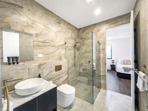 a bathroom with a sink and a toilet and a shower at Casa Divina in Pokolbin +23 photos