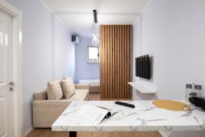 een woonkamer met een bank en een tafel bij Trio Apartment's City Center Tirana in Tirana