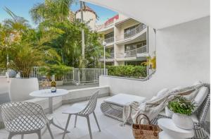un patio con sillas y mesas y un edificio en Copacabana Apartments, en Gold Coast