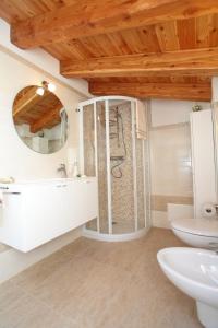 een badkamer met een douche, een wastafel en een spiegel bij Albergo Diffuso Polcenigo D. Brolo in Polcenigo