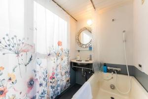 a bathroom with a tub and a sink and a shower curtain at M'sHouse in Tokyo
