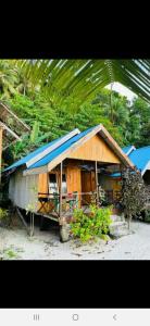 a small house with a blue roof at Pondok Lestari Kadidiri in Batudaka