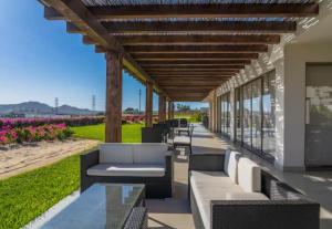 a patio with couches and tables on the beach at Lumina at Vista Velas II Los Cabos in El Pueblito