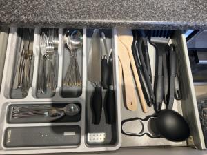 a drawer filled with utensils on top of a counter at Visit Luton With This 2 BR Rental - Sleeps 6 in Luton