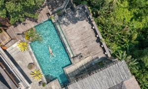 una vista aérea de una piscina con una persona en ella en Kawi Resort A Pramana Experience en Tegalalang