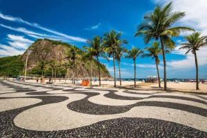 een uitzicht op een strand met palmbomen en een rotsformatie bij Arpoador Design - Quadra da Praia e WIFI 500Mb in Rio de Janeiro