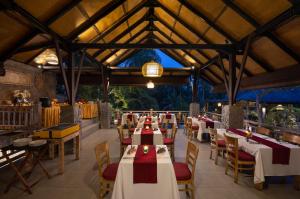a dining room with tables and chairs and a ceiling at Kawi Resort Ubud in Tegalalang