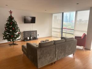 uma sala de estar com uma árvore de Natal e um sofá em bnb2night Polanco-Lomas em Cidade do México