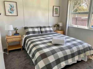 - une chambre avec un lit noir et blanc et une fenêtre dans l'établissement Charming Mid Century Bungalow, à Stanthorpe