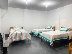a room with three beds in a room at Kaypi House in Pisco