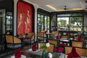 een restaurant met tafels en stoelen met rode servetten bij Serene Nature Hotel & Spa in Hội An