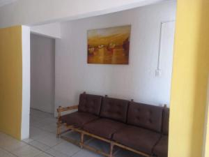 a couch in a living room with a painting on the wall at Pousada Praia Avenida in Maceió