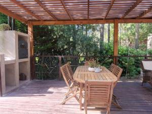 a wooden table and chairs on a wooden deck at Casa en Cariló para 16 personas in Carilo