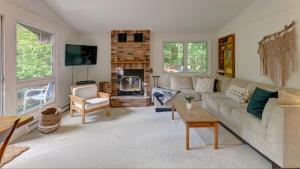a living room with a couch and a fireplace at Chalet dans les arbres. 3 ch. /trees house 3bdr in Lac Sainte-Marie