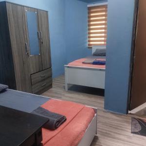 een kamer met 2 bedden en een spiegel bij Nur Aisyah homestay kemaman..3 bedrooms in Kampong Kemaman