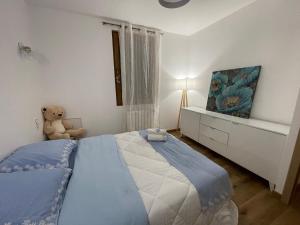 una camera con un grande letto e un orsacchiotto di Villa Segny a Ségny