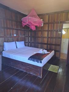 东德岛Riverside Bungalow Don Det的卧室里有一张床，嵌在木墙里