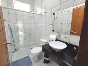 a bathroom with a toilet and a sink and a mirror at Apartamento em Ilha bela in Ilhabela +26 photos