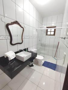 Baño blanco con lavabo y aseo en Apartamento em Ilha bela, en Ilhabela