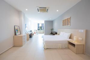 a bedroom with a large white bed and a room at Golden View Serviced Apartments in George Town