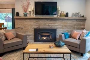 a living room with a fireplace with two couches and a table at Rustic Chic Cottage near Mill Creek, Snohomish, Woodinville in Bothell