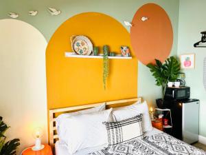 a bedroom with a bed with an orange headboard at Somerset Hotel in San Diego