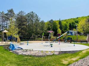 een park met een speeltuin met een glijbaan bij LAÖ Loft Tremblant #105 - KING size bed in Mont-Tremblant