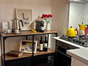 a kitchen with a table with a stove and some bottles of wine at Lovely 2 Bedroom in San Gimignano Historic Center in San Gimignano