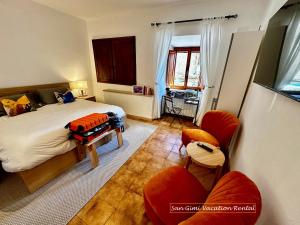 a bedroom with a bed and two chairs at Lovely 2 Bedroom in San Gimignano Historic Center in San Gimignano
