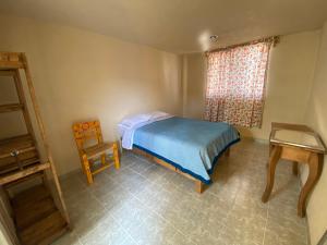 una camera con un letto e una sedia e una finestra di Casa Meraki a Ixmiquilpan