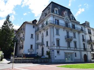 ein weißes Gebäude mit einem schwarzen Dach in der Unterkunft Appartement charmant avec balcon, wifi et animaux admis à Évian-les-Bains - FR-1-498-14 in Évian-les-Bains