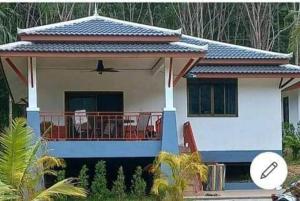a house with a balcony with a table on it at Koh Lanta MaiKaew Villa in Ban Ru Yai