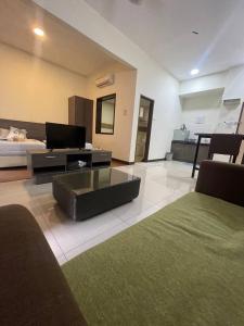een woonkamer met een bed en een salontafel bij Junikastay BLagoon Melaka in Melaka