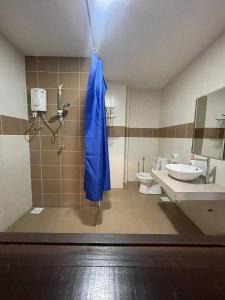 a bathroom with a blue umbrella hanging from the shower at Junikastay BLagoon Melaka in Malacca