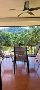 a patio with two chairs and a table and a ceiling fan at Koh Lanta MaiKaew Villa in Ban Ru Yai