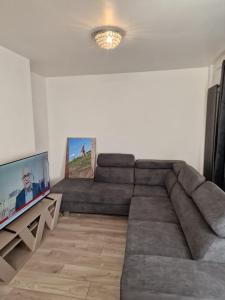 a living room with a large couch and a flat screen tv at Walker Lodge in Oldbury