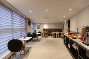 uma cozinha e sala de jantar com mesas e cadeiras em Brown Dot Hotel Hadan em Busan
