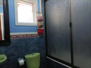 baño con aseo verde y ventana en EL URCO CHILOE HOSTEL en Ancud