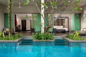 a hotel pool with a bedroom in the background at Twinpalms Phuket in Surin Beach