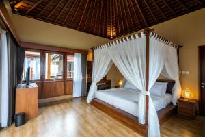 a bedroom with a bed with a canopy at Shankara Munduk Bali in Munduk