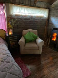 a room with a chair with a green pillow on it at BAJO EL ÑIRE in San Carlos de Bariloche