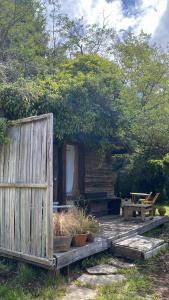 a cabin with a wooden fence and some plants at BAJO EL ÑIRE in San Carlos de Bariloche