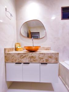 a bathroom with a wooden sink and a mirror at POUSADA E RESTAURANTE GAROUPA in São Miguel dos Milagres