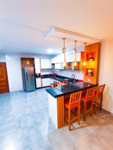 a kitchen with a counter and some chairs in it at POUSADA E RESTAURANTE GAROUPA in São Miguel dos Milagres