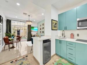 a kitchen with blue cabinets and a dining room at Park Place South of Fifth in Miami Beach